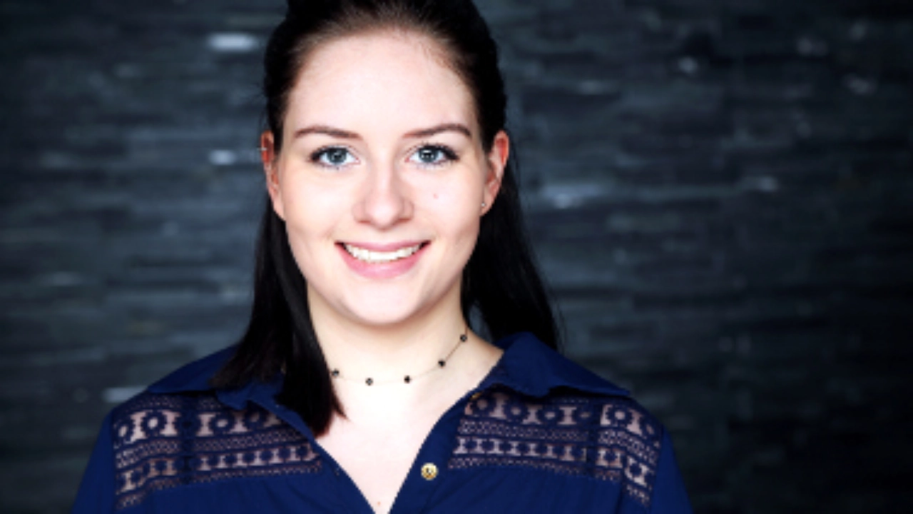 Alexandra Hochhaus blickt lächelnd in die Kamera.