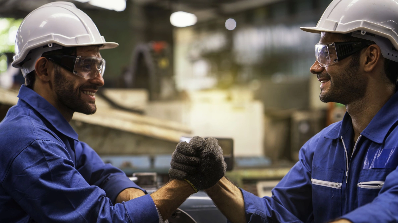 Industriearbeiter geben sich in Fabrik die Hände