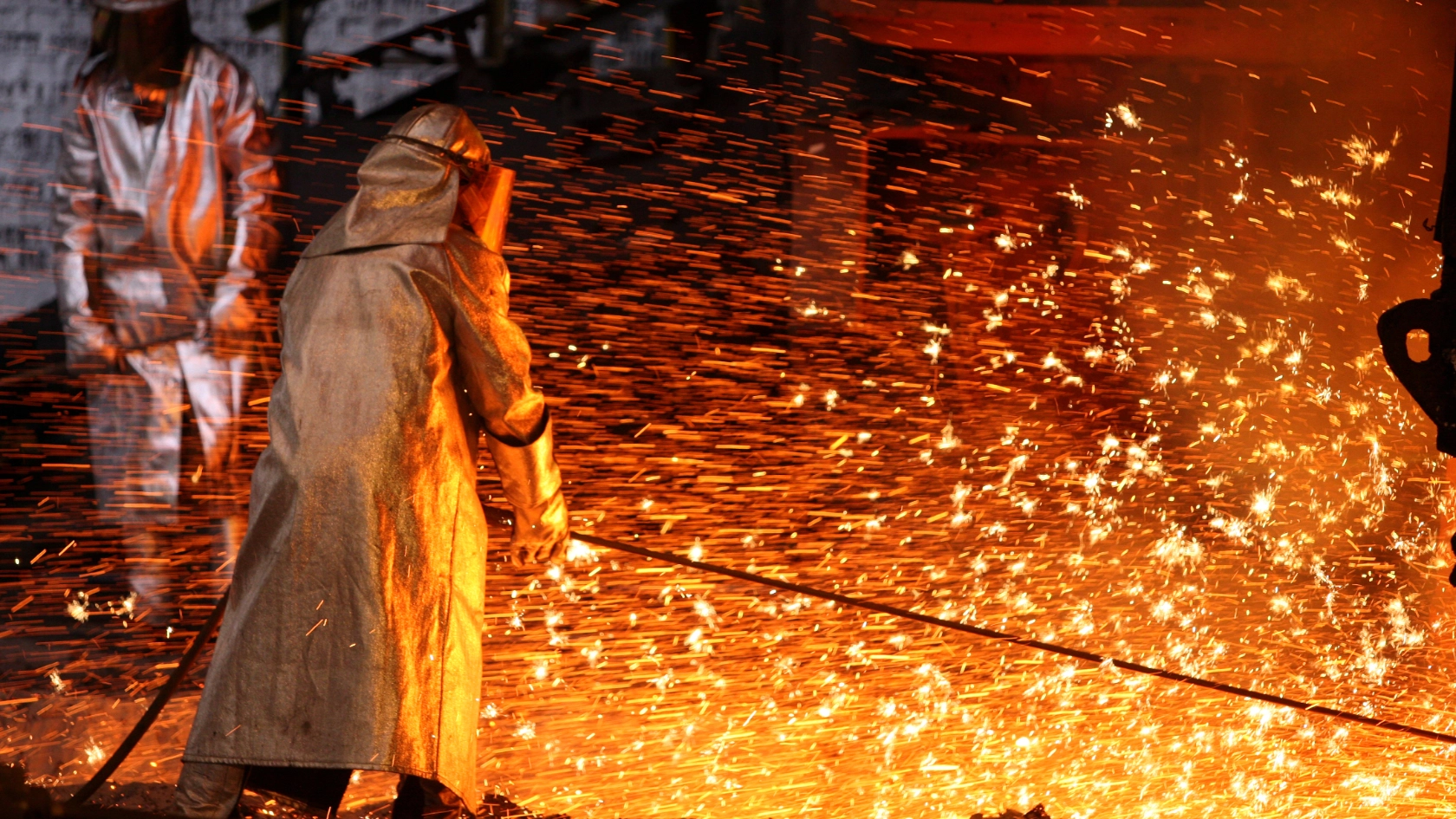 Zwei Stahlarbeiter bei der Arbeit.