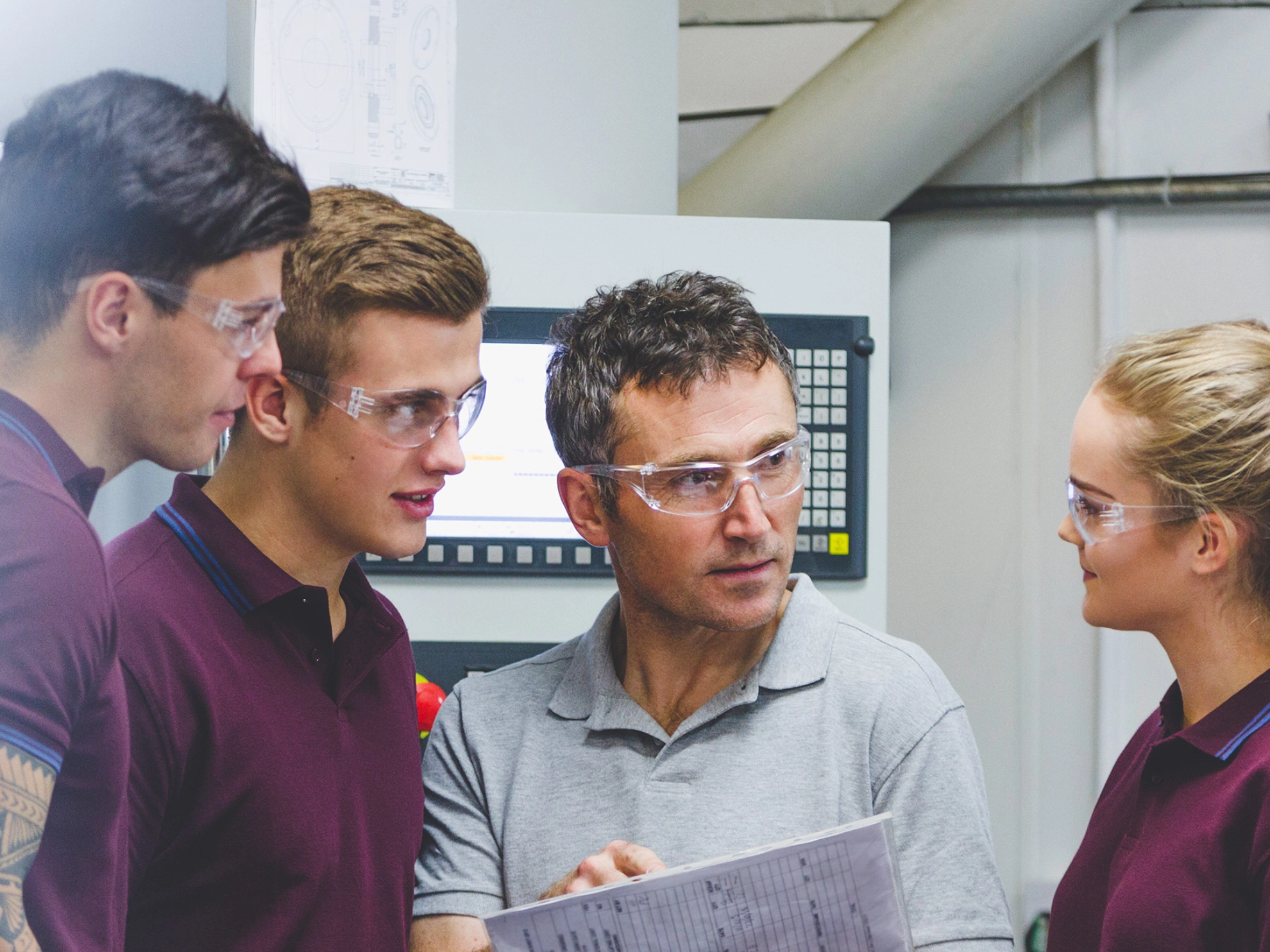 Ausbilder mit drei Auszubildenden