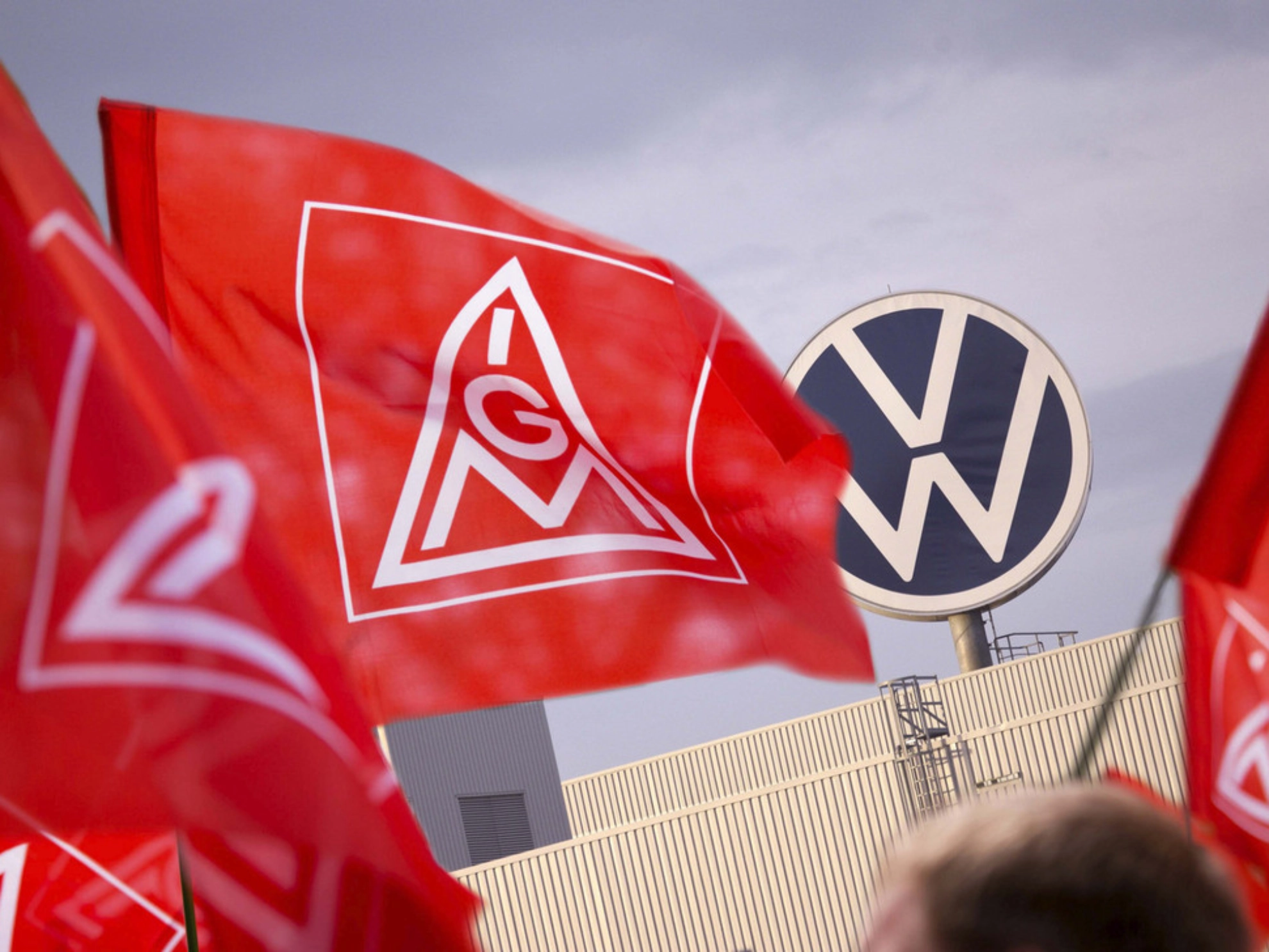 IG Metall-Fahnen vor dem Volkswagen-Logo