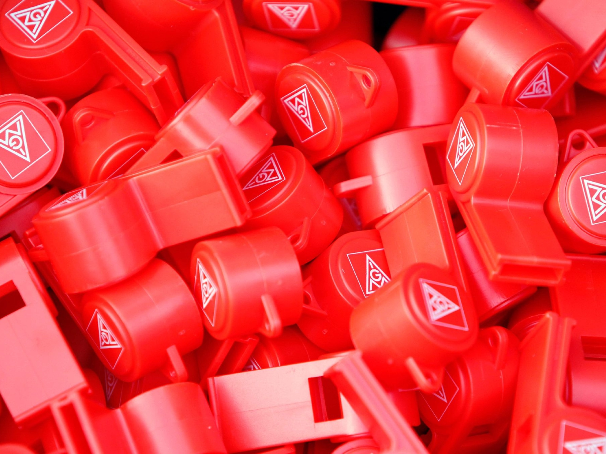 Viele rote Trillerpfeifen mit dem Logo der IG Metall.