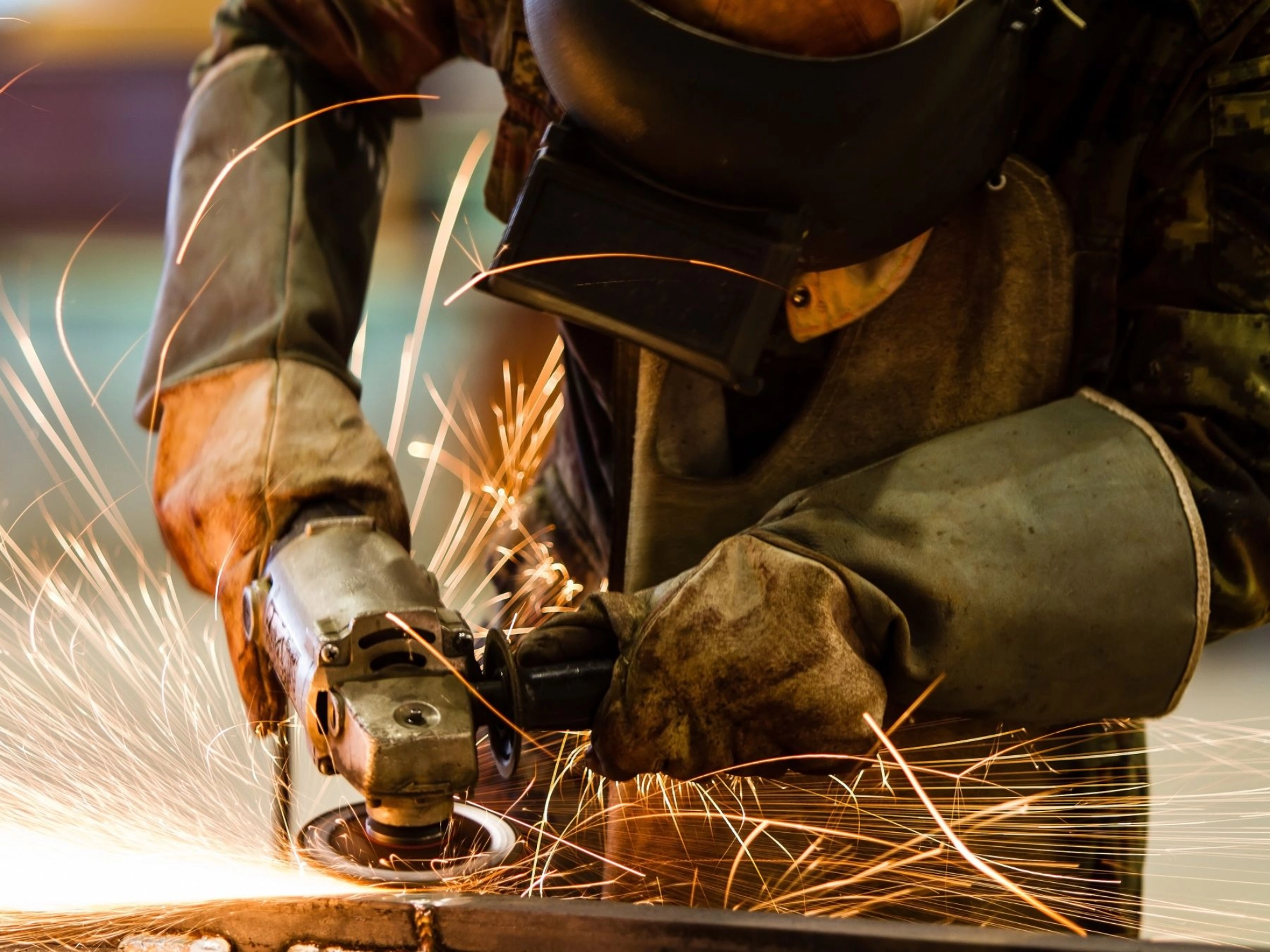 Ein Beschäftigter schleift Metall im Metallhandwerk