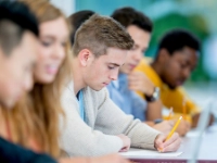 Ein Student macht sich Notizen während eines Seminars.